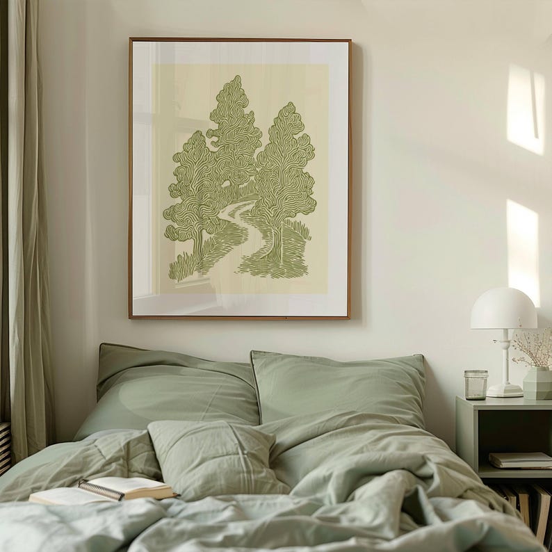 K&ouml;nnte beinhalten: Ein gerahmter Kunstdruck mit einer gr&uuml;n-wei&szlig;en Illustration von B&auml;umen und einem gewundenen Pfad. Das Kunstwerk h&auml;ngt &uuml;ber einem Bett mit salbeigr&uuml;ner Bettw&auml;sche. Eine wei&szlig;e Lampe und ein Nachttisch sind ebenfalls zu sehen.