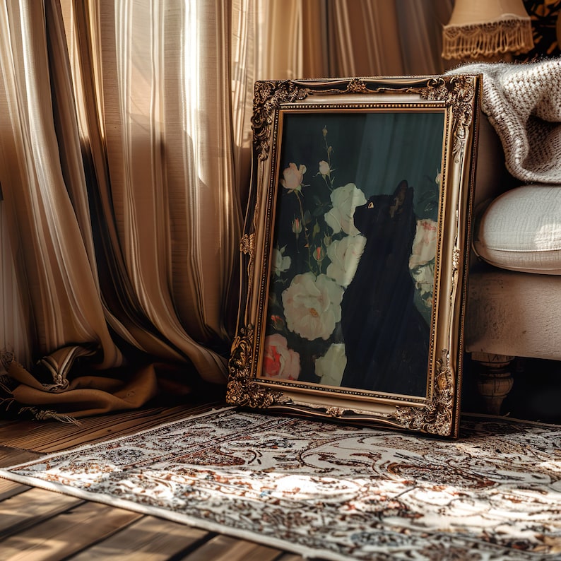 May include: A black cat silhouette in a framed painting with white roses and green leaves. The painting is in a gold ornate frame and is leaning against a white couch.