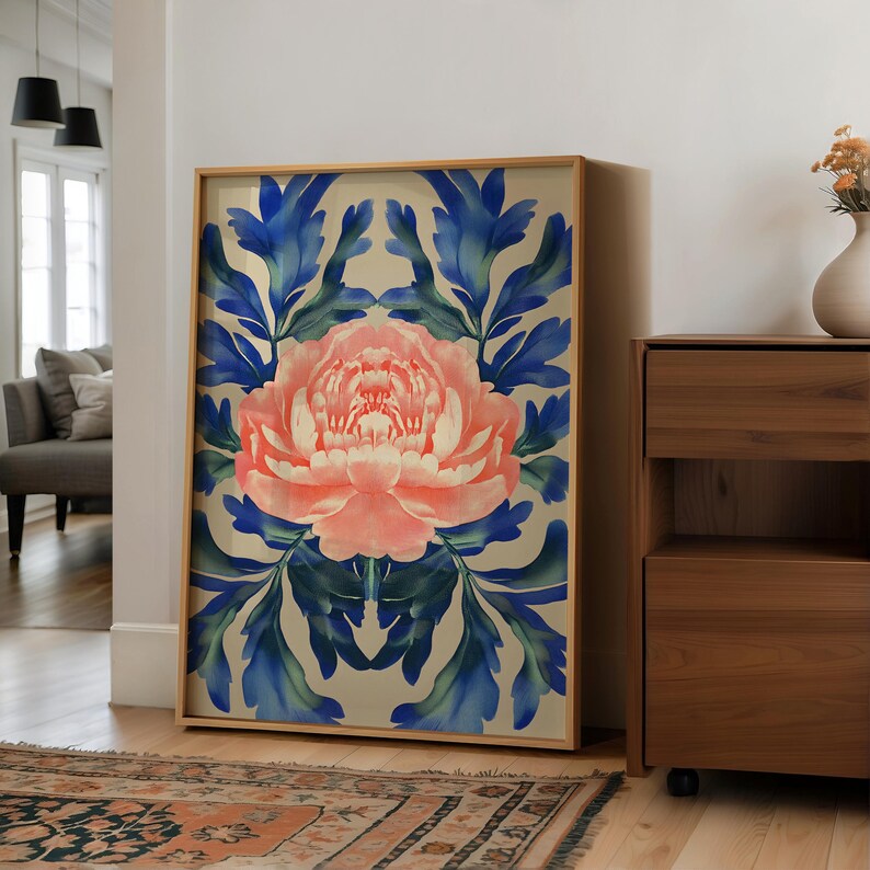 May include: A framed print of a pink flower with blue leaves on a cream background. The flower is in the center of the print and is surrounded by leaves. The print is in a wooden frame.