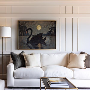 May include: A white sofa with black and beige throw pillows sits in front of a wall with wainscoting. A framed painting of a black swan on a lake with a full moon hangs above the sofa. A gold floor lamp stands to the left of the sofa.