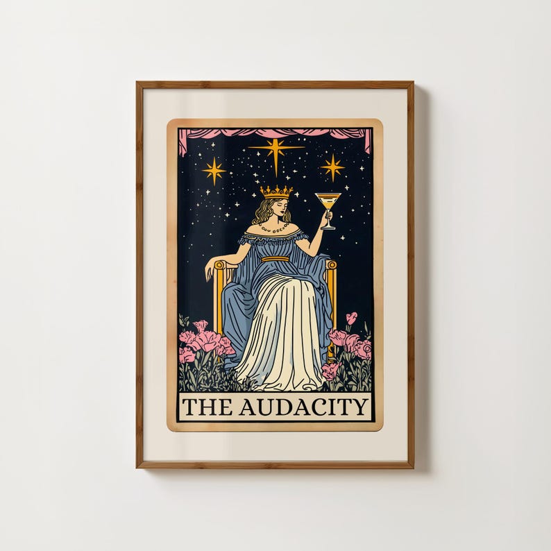 Puede incluir: Impresi&oacute;n enmarcada de una carta del tarot que representa a una mujer con un vestido azul y una corona dorada, sosteniendo un c&oacute;ctel. El fondo es un cielo estrellado con flores rosas en la parte inferior. El texto "THE AUDACITY".