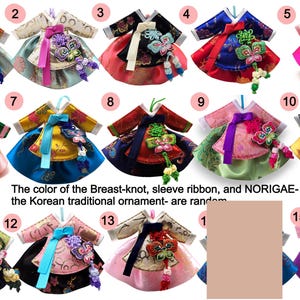 K&ouml;nnte beinhalten: Eine Sammlung von vierzehn Miniatur-Hanbok-Ornamenten mit verschiedenen Farbkombinationen aus Satin, gemusterten Oberteilen und R&ouml;cken. Jedes Kleidungsst&uuml;ck enth&auml;lt ein dekoratives Norigae-Schmetterlingsornament und ein Band an der Brust.