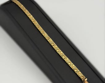 May include: A yellow gold bracelet featuring a series of interconnected, textured nugget-style links. The bracelet has a polished finish and includes a secure clasp mechanism at one end, showcasing a repeating organic, irregular pattern throughout.