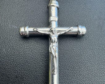 May include: Silver-toned crucifix pendant with a detailed depiction of Jesus Christ on the cross. The pendant hangs from a silver rope chain. The cross has rounded ends and the letters INRI are visible.
