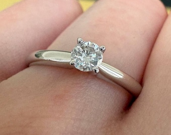 Peut inclure: Une bague de fiançailles solitaire en argent avec un diamant rond et clair.