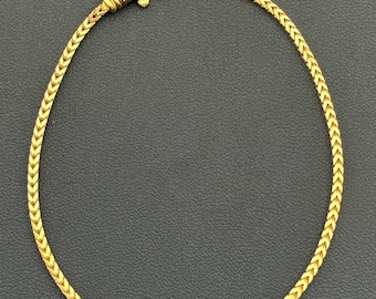 May include: A gold chain necklace with a delicate, braided design. The chain is approximately 18 inches long and has a lobster claw clasp.