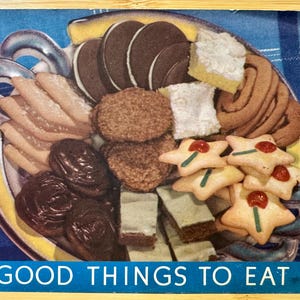 May include: A blue and yellow plate filled with a variety of cookies, pastries, and other treats. The plate is on a blue and white checked tablecloth. The text "GOOD THINGS TO EAT." is printed below the plate.