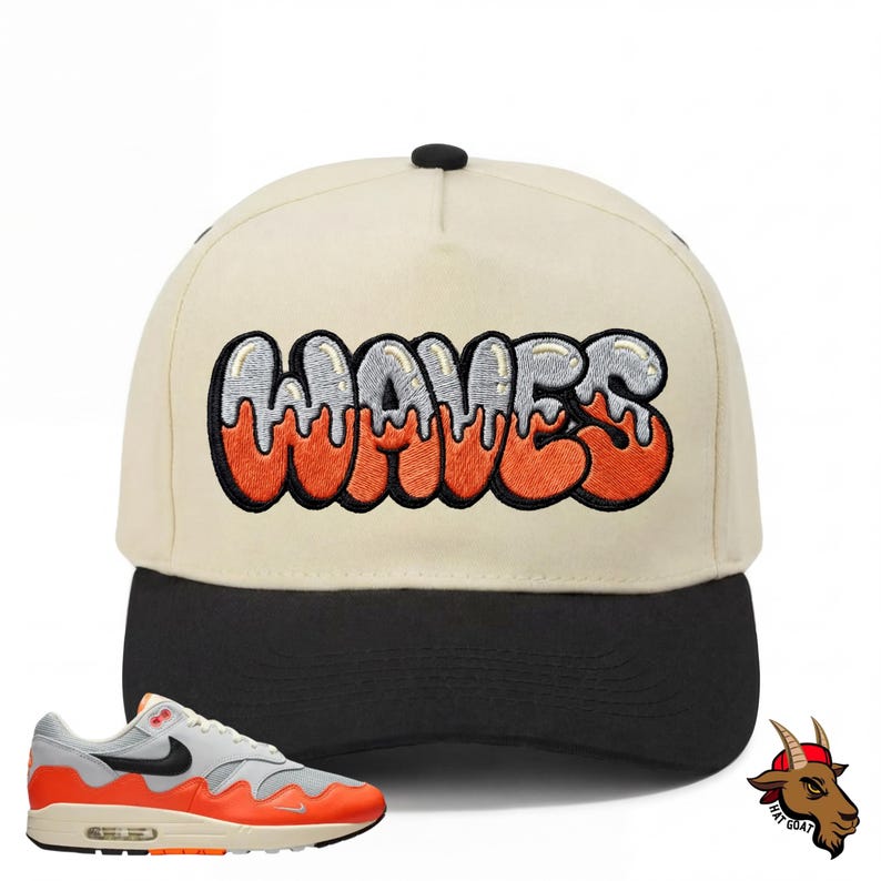K&ouml;nnte beinhalten: Cremefarbene Baseballkappe mit dem Wort "WAVES" in orangefarbener und silberner Stickerei. Die Kappe hat einen schwarzen Schirm und einen schwarzen Knopf oben. Ein grauer, orangefarbener und schwarzer Sneaker befindet sich in der unteren linken Ecke.