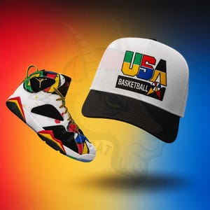 Puede incluir: Una zapatilla de deporte de caña alta y una gorra de béisbol. La zapatilla es blanca con detalles en negro, rojo, amarillo y azul y un logotipo dorado. La gorra blanca tiene una visera negra y un gráfico con el texto USA BASKETBALL en rojo, amarillo, verde y azul.