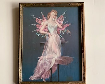May include: Vintage framed print featuring a woman in a sheer gown, leaning on a table with a telephone. The artwork has a dark blue background with pink flowers and a gold-toned frame. The print is signed.