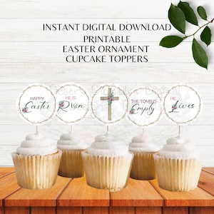 Könnte beinhalten: Cupcakes mit Ostern-Themen-Toppern. Die runden Topper zeigen Sätze wie "Happy Easter Risen" und ein Kreuz-Design. Die Cupcakes sind auf einem Holztisch angeordnet. Der Text "Printable Easter Ornament Cupcake Toppers" ist ebenfalls sichtbar.