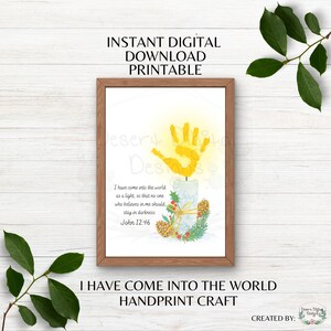 May include: A framed digital printable featuring a yellow handprint above a candle illustration. The candle is decorated with holly and pinecones. Text includes "I HAVE COME INTO THE WORLD HANDPRINT CRAFT" and "INSTANT DIGITAL DOWNLOAD PRINTABLE".