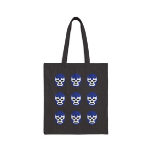 May include: Black tote bag with a white background and a repeating pattern of blue and white luchador masks.