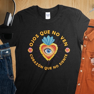 May include: Black t-shirt with a graphic of a heart with an eye and the text "Ojos que no ven corazón que no siente".