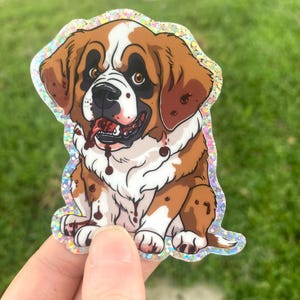 May include: A sticker featuring a cartoon Saint Bernard puppy. The puppy is brown and white with blood splatters on its face and body. The sticker has a glittery, iridescent border. The puppy's expression is mischievous and slightly menacing. The sticker is a collectible item for dog lovers and fans of horror-themed art.