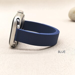 May include: A silver smartwatch with a navy blue leather band. The band is a solid color and has a textured surface. The word "BLUE" is printed in the bottom right corner.