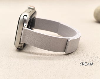 May include: A cream-colored smartwatch with a light gray leather band. The band has a textured surface and is connected to the silver watch face. The word "CREAM" is printed on the surface.