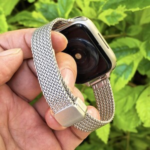 以下が含まれることがあります： メッシュデザインのシルバーメタルApple Watchバンド。バンドは調節可能で、マグネット式留め具が付いています。