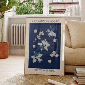 Könnte beinhalten: Ein gerahmter Druck mit blauem Hintergrund und weißen floralen Designs. Der Text "I just wanted you to know that this is me trying" ist oben und unten auf dem Druck in Weiß gedruckt.
