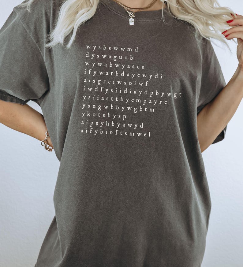 K&ouml;nnte beinhalten: Ein dunkelgraues T-Shirt mit wei&szlig;em Text, der lautet: "wysbswwmd dyswagUOB wywabwyascs ifywatbdaycwydi aisgrciwsoiwf iwdffysidiaydpbbywgt ysiiaasttbdycpayrc ysnqwbbywgbtm ykotsbysp aipsyhbbyawyd aifybinftsmwel"