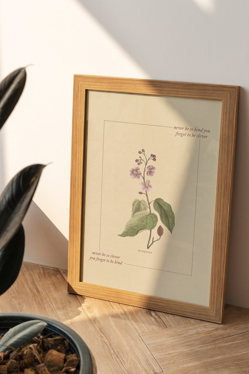May include: A framed print with a botanical illustration of a Marjorie flower. The print features the text "never be so clever you forget to be kind" and "never be so kind you forget to be clever".
