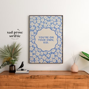 May include: A blue and white floral print poster with the text "You're on your own, kid." in a white circle.