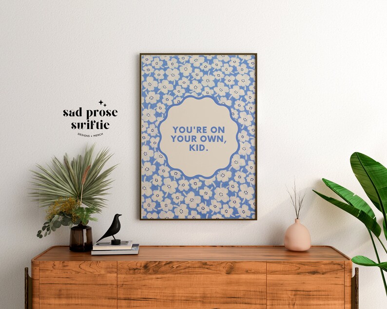 May include: A blue and white floral print poster with the text "You're on your own, kid." in a white circle.