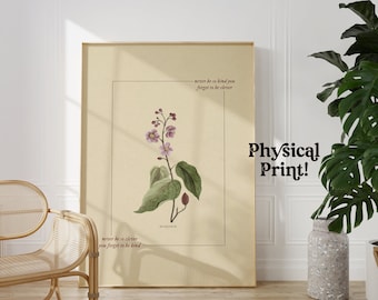 May include: A beige poster with a botanical illustration of a plant with purple flowers and green leaves. The poster has the text "never he is clever you forget to be kind" and "never be so kind you forget to be clever" printed on it. The poster is framed in a light wood frame and is hanging on a white wall. The text "Physical Print!" is printed in black on the wall.