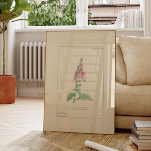 May include: A framed botanical print of a pink foxglove flower with the text "slowly, my tattered heart, left all their broken parts, my own skin began to grow, my favorite time"