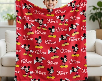May include: A red fleece blanket featuring a repeating pattern of Mickey Mouse in various poses and the name Oliver printed in white script. The blanket displays multiple instances of the character wearing red shorts and yellow shoes throughout.