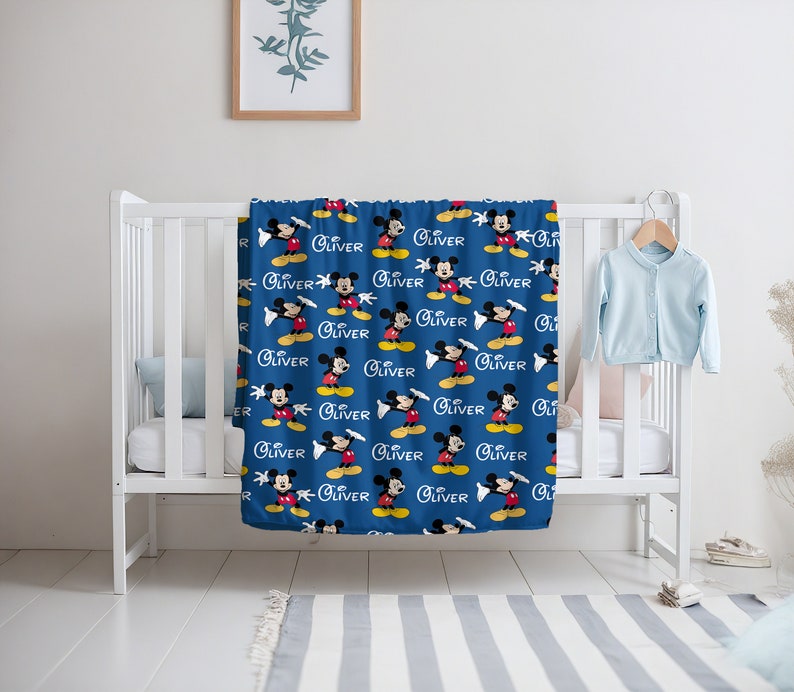 May include: A blue baby blanket with a repeating pattern of Mickey Mouse and the name "Oliver".