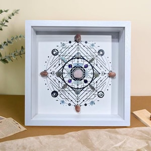 Könnte beinhalten: Ein quadratischer Druck in einem weißen Rahmen mit einem geometrischen Design in Schwarzweiß, das ein Kristallmandala mit verschiedenen farbigen Kristallen zeigt, darunter rosa, lila, blau und braun.