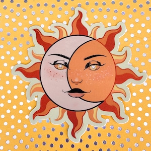 May include: A die-cut sticker featuring a sun and moon design. The sun side is orange with freckles and a heart eye, while the moon side is light pink with a star eye. The sun has orange and red rays, set against a yellow background.