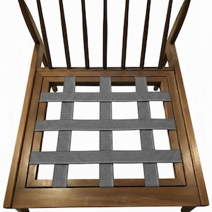 May include: Wooden chair with a curved back and vertical slats. The seat features a woven gray fabric design. The chair has a classic design and is made of a warm-toned wood.