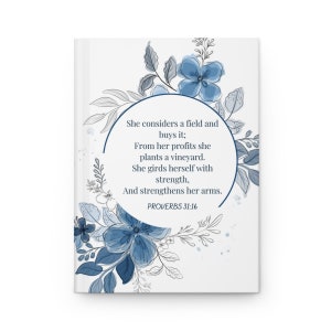 May include: A white background with blue floral designs and a circle containing the text "She considers a field and buys it; From her profits she plants a vineyard. She girds herself with strength, And strengthens her arms. PROVERBS 31:16"