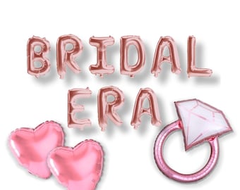 May include: Rose gold "BRIDAL ERA" balloon banner with two pink heart-shaped balloons and a pink and white diamond ring balloon. Perfect for a bridal shower or bachelorette party.