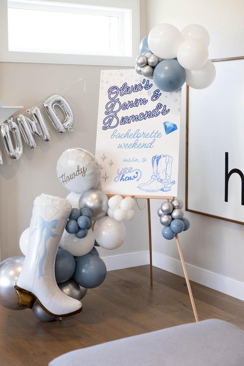 May include: A party scene with balloons and a sign. The sign reads "Olivia's Denim & Diamonds bachelorette weekend" with a drawing of a cowboy boot. Balloons are white, silver, and blue. A large boot-shaped balloon is also present.