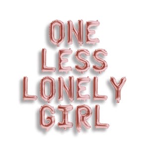 May include: Rose gold foil letter balloons arranged to spell out the phrase ONE LESS LONELY GIRL. Each individual balloon is shaped like a capital letter, creating a metallic, reflective text display against a plain white background.