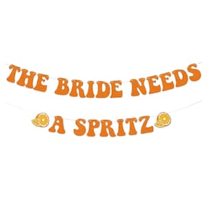 Op de afbeelding: Oranje banner met de tekst "THE BRIDE NEEDS A SPRITZ" in een retro lettertype. De banner bevat illustraties van sinaasappelschijfjes. Perfect voor een bruidsfeest of vrijgezellenfeest.