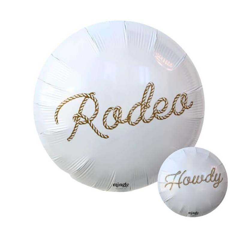May include: White foil balloon with the word "Rodeo" in gold rope lettering. A smaller balloon with the word "Howdy" is also visible. Both balloons are round and have the brand name "mingle" printed on them.