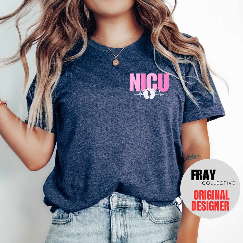 Pu&ograve; includere: Una maglietta blu navy con una grafica rosa che dice "NICU" con una linea di battito cardiaco e un paio di impronte di piedi di bambino bianche. Il testo "FRAY COLLECTIVE ORIGINAL DESIGNER" &egrave; in un cerchio bianco nell'angolo in basso a destra dell'immagine.