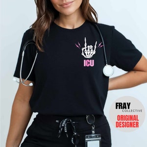 May include: Black t-shirt with a white skeleton hand making a rock and roll sign with pink lightning bolts and the word "ICU" in pink letters.