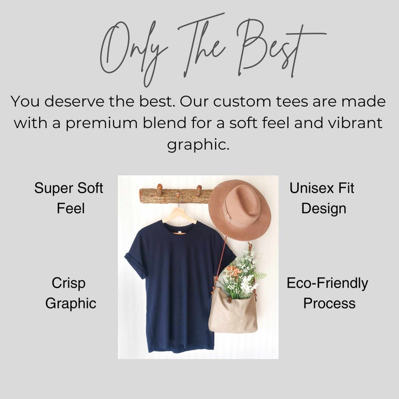May include: A navy blue t-shirt hanging on a wooden rack with a brown hat and a small bag with flowers. The text "Only The Best" is at the top of the image. The text "Super Soft Feel" is on the left side of the image. The text "Unisex Fit Design" is on the right side of the image. The text "Crisp Graphic" is on the left side of the image. The text "Eco-Friendly Process" is on the right side of the image.