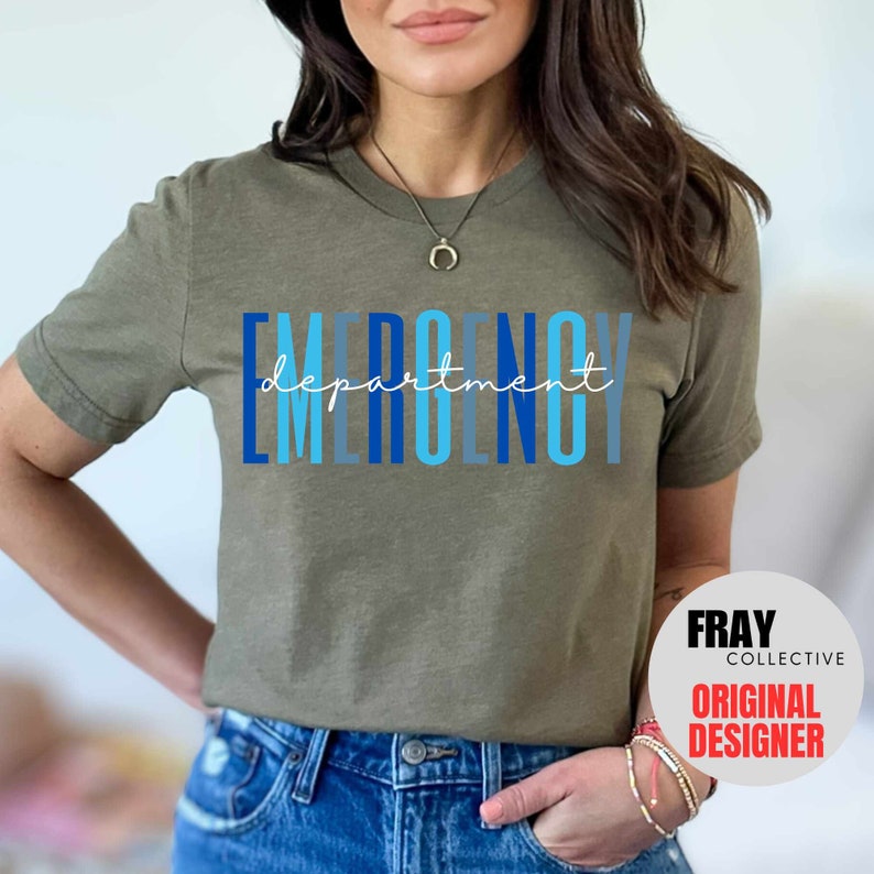 May include: A green t-shirt with the text "EMERGENCY department" in blue and light blue lettering. The text is stacked vertically with the word "department" in a smaller font size and written in cursive. The t-shirt is being worn by a person. The image also includes a white circle with the text "FRAY COLLECTIVE ORIGINAL DESIGNER" in black text.