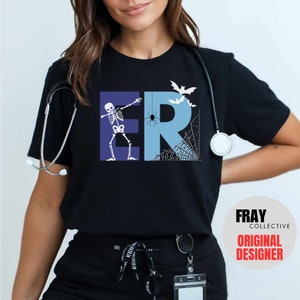 May include: Black t-shirt with a Halloween-themed design. The design features the letters "ER" in blue, with a skeleton dabbing, a spider, bats, and a spiderweb. The shirt also has the text "FRAY COLLECTIVE ORIGINAL DESIGNER".