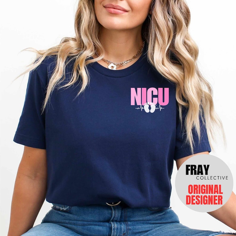 Pu&ograve; includere: Una maglietta blu navy con il testo "NICU" in lettere rosa e un grafico di battito cardiaco rosa con impronte di piedi di bambino. Il testo "FRAY COLLECTIVE ORIGINAL DESIGNER" &egrave; visibile nell'angolo in basso a destra.