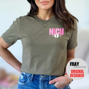 Pu&ograve; includere: Una maglietta verde con una grafica rosa che dice "NICU" con una linea di battito cardiaco e impronte di piedi rosa. Il testo "FRAY COLLECTIVE ORIGINAL DESIGNER" &egrave; su un cerchio bianco nell'angolo in basso a destra dell'immagine.