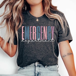 May include: A dark gray t-shirt with the text "EMERGENCY department" printed in pink, blue, and purple. The text is stacked vertically with each letter in a different color.
