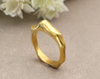 The Minimalist Organic Wavy Band Ring, featuring a molten, uneven texture in brass And Silver is the perfect modern stacking piece.