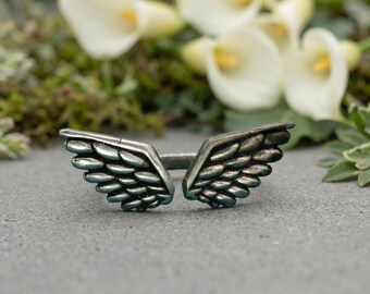 The Sterling Silver Angel Wings Adjustable Ring features two intricately detailed, oxidized feather wings meeting, Christmas gift